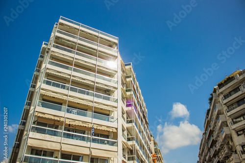 common apartment building in south Europe summer clear weather time foreshortening from below with sun glare reflection from window and highlight