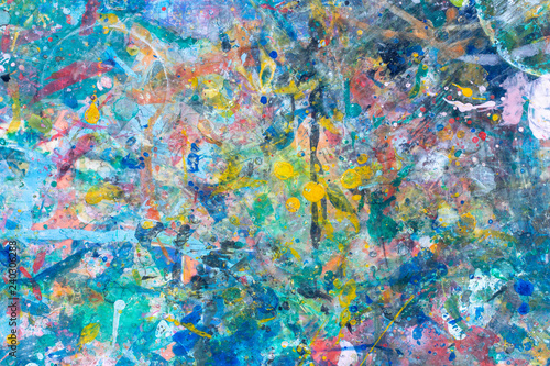 close up the colorful water color art and abstract on top of a child table covered in paint splatter