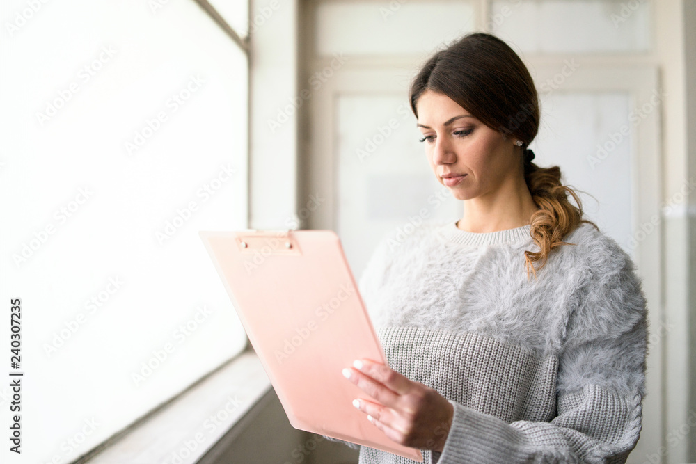 young woman with clipboard at the office young woman with clipboard at the office