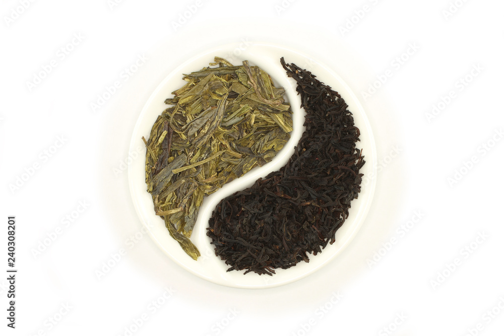 Green and black tea in round Yin and Yang saucer on white background Green and black tea in round Yin and Yang saucer on white background