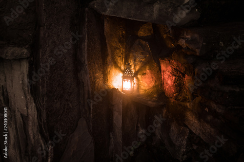 Beautiful colorful illuminated lamp in the garden in misty night. Retro style lantern at night outdoor.