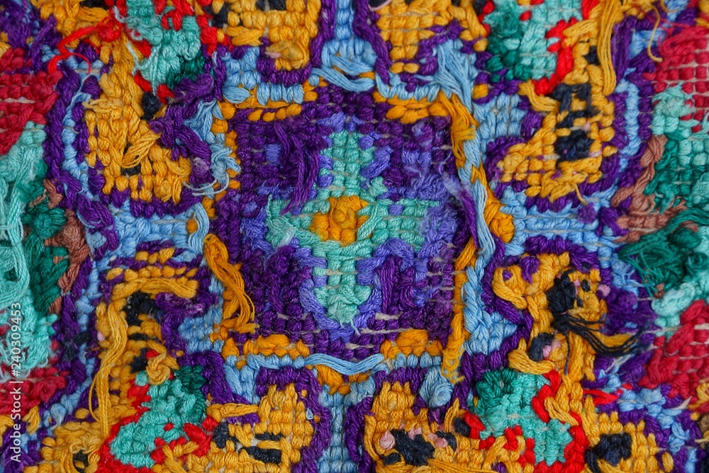 colored fabric texture from embroidered threads on a piece of old clothes with a bright pattern colored fabric texture from embroidered threads on a piece of old clothes with a bright pattern