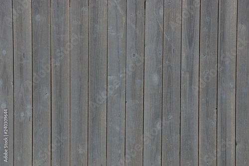 gray wooden texture of thin planks in the wall of the fence