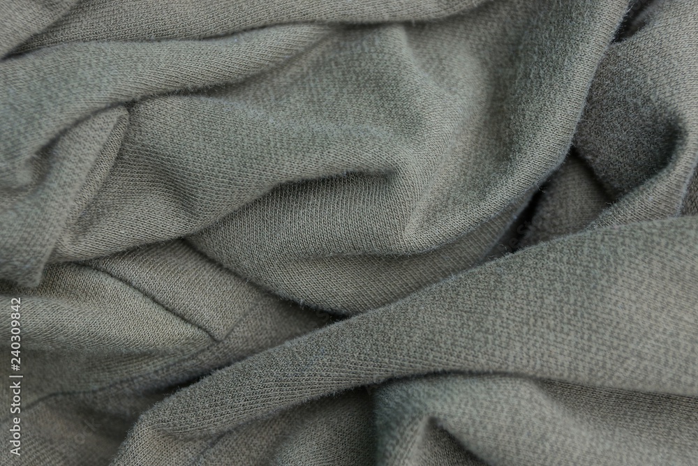 gray green background of fabric from a crumpled fragment of clothes gray green background of fabric from a crumpled fragment of clothes