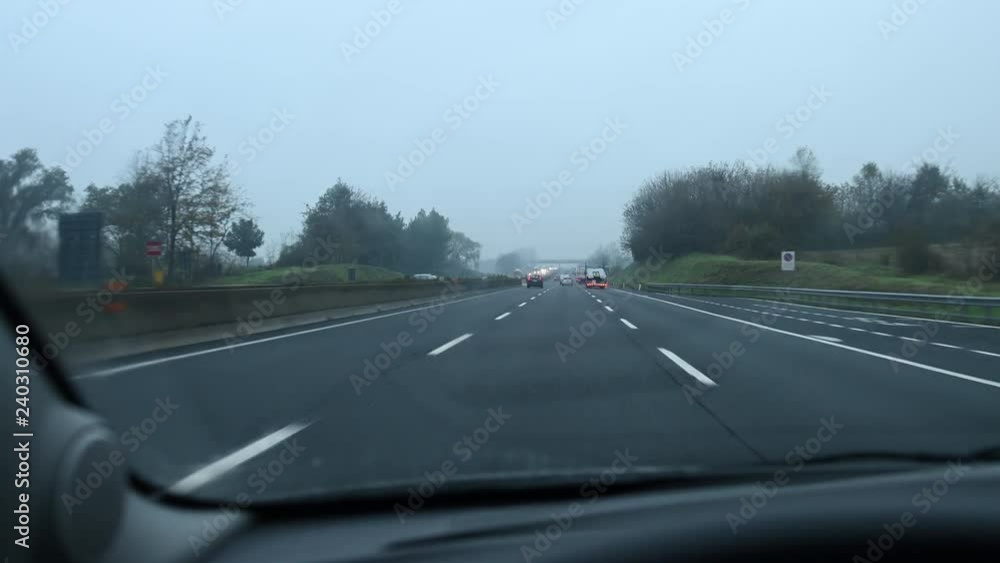 A car is traveling on a highway during a rainy day. A car is traveling on a highway during a rainy day.
