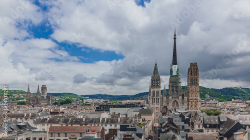 Towers and front façade of the Rouen Cathedral over medieval street and buildings of the city center of Rouen, France