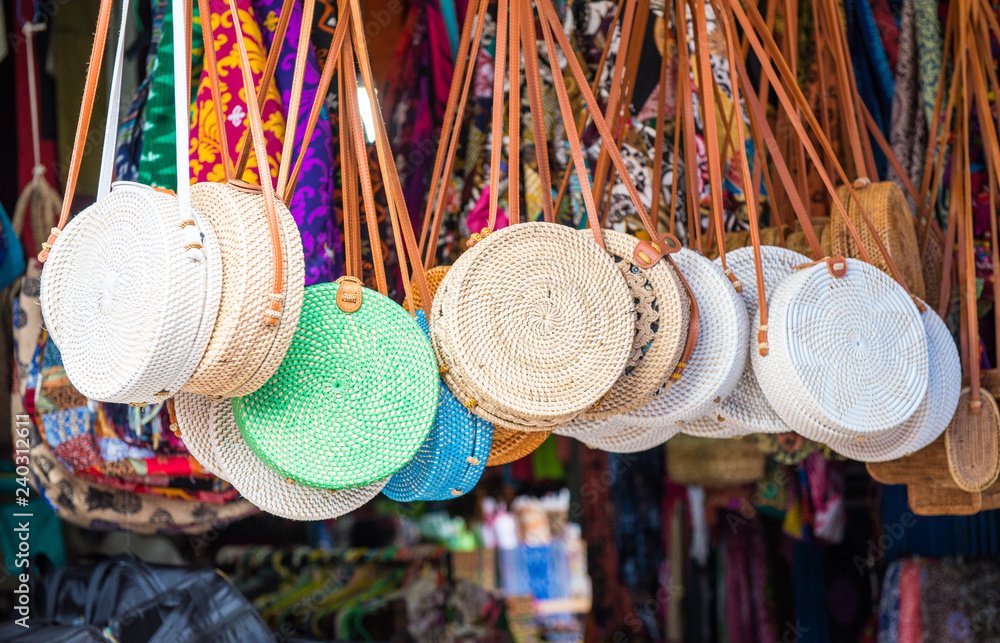 Iconic rattan hand bags hanging for souvenir at a street shop in Ubud market of Bali island, Indonesia. - obrazy, fototapety, plakaty 