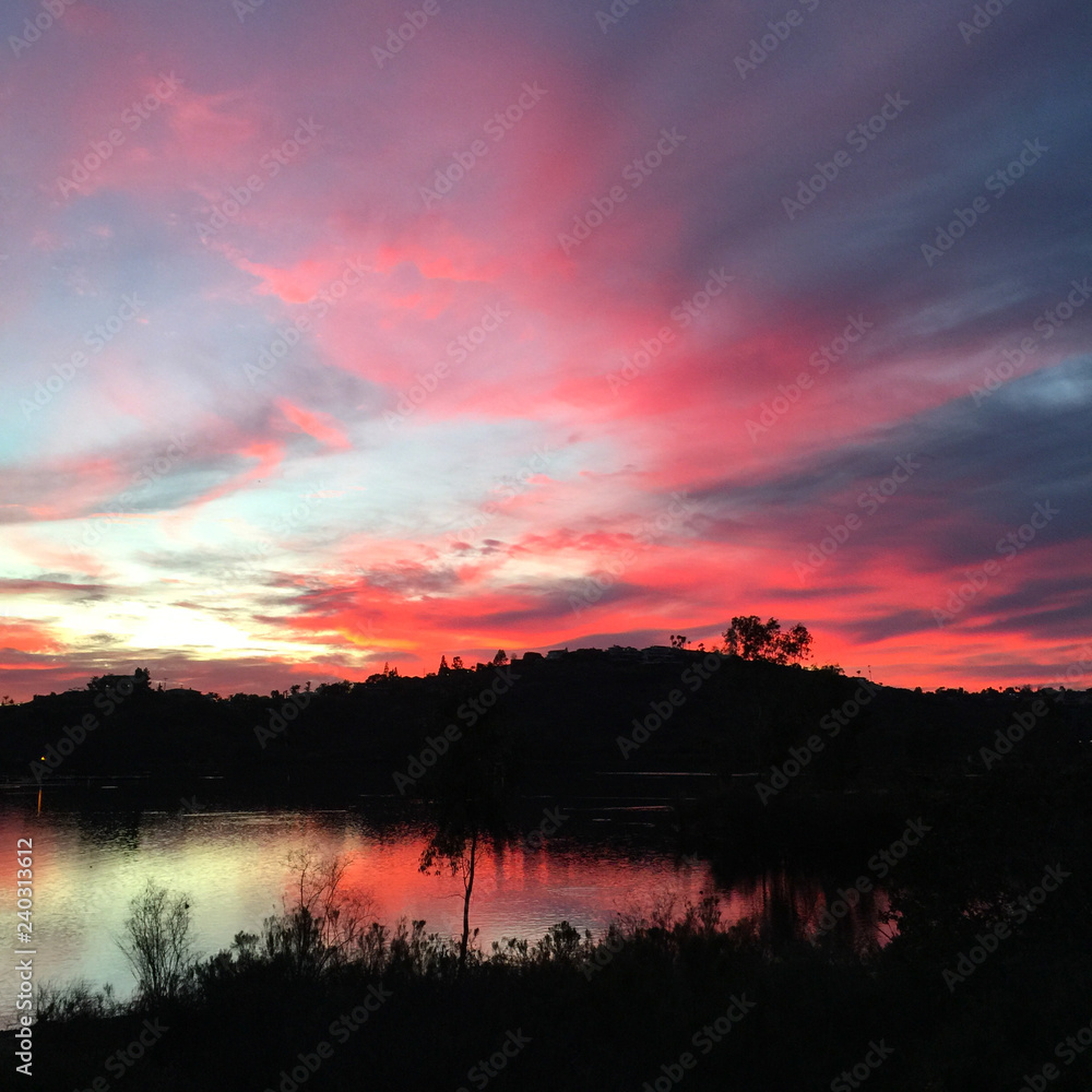 Fototapeta premium Magical pink silhouette sunset reflecting over a serene lake in San Diego