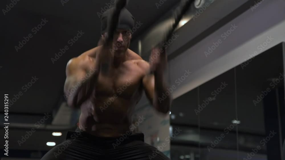 Adult male athlete with tattoos on his arms exercising in the gym. Adult male athlete with tattoos on his arms exercising in the gym.