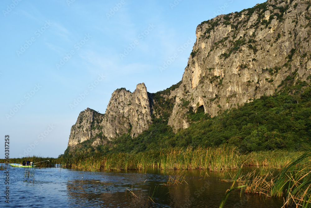 Rock cliff and green forest on limestone mountain on the vast wetland at Khao Sam Roi Yot National Park , Thailand 