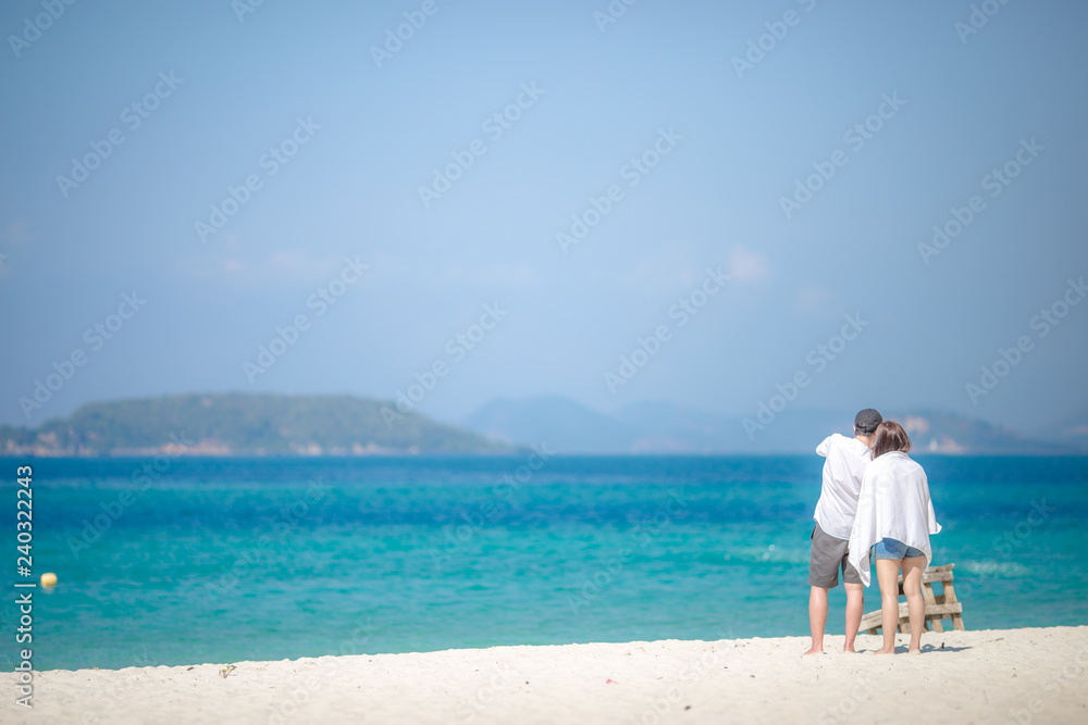 The background of young couples walking around the seashore, taking pictures together with the colorful sky, often seen in tourist attractions and places according to the occasion