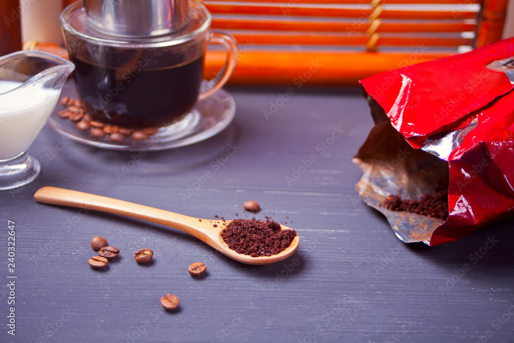 Cup of coffee and spoon with coffee powder on the wooden table Cup of coffee and spoon with coffee powder on the wooden table