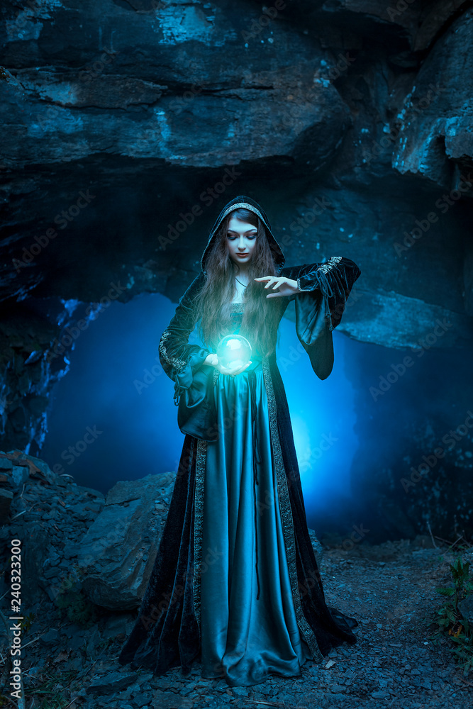 Fotografie The witch with magic ball in her hands causes a spirits