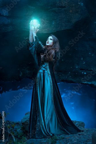 The witch with magic ball in her hands causes a spirits