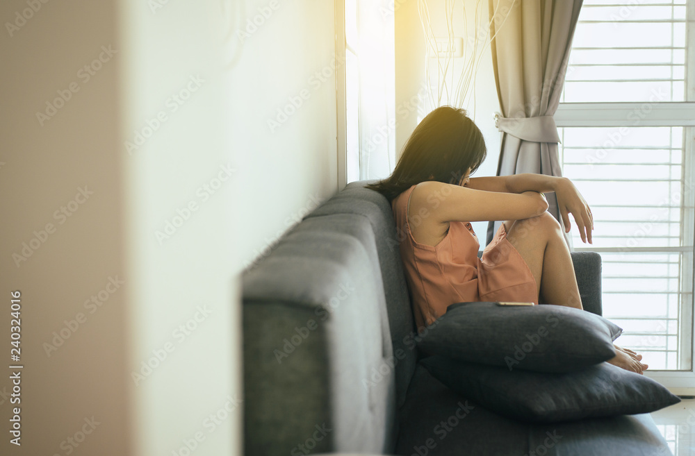 Φωτογραφία Asian woman sitting on sofa in living room,Women feeling confused and anxious,Un