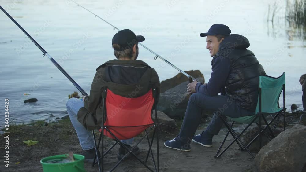 Two friends fisherman fishing and drinking beer, resting weekend, good company
