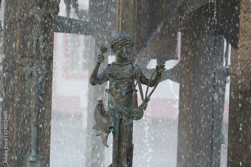 Metal young kid statue playing amoung rain water drop at mainz, Germany