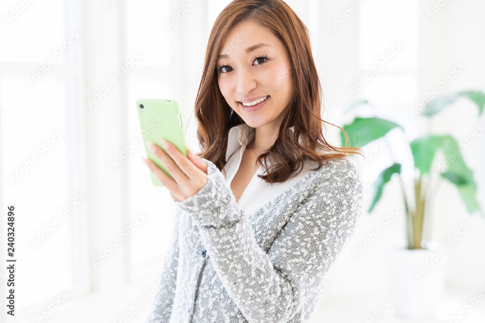 部屋でスマホを見る女性 部屋でスマホを見る女性