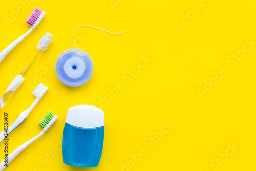 Tooth care with toothbrush, dental floss. Set of cleaning products for teeth on yellow background top view copy space
