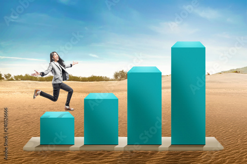 Young asian business woman running to the highest graph