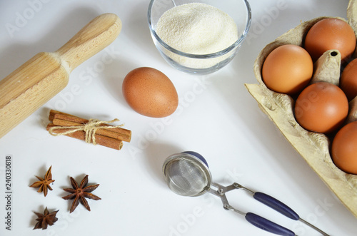 Egg, cinnamon, honey, almond flour, flax seeds, vanilla extract, salt. Ingredients for bread muffins. rolling pin, star of anis on the white background