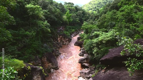 Beautiful nature with large rock hill mountain water flowing and wood bridge link a cliff above the river in the forest at Obluang national park, Chiangmai, Thailand.