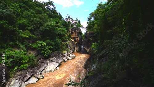 Beautiful nature with large rock hill mountain water flowing and wood bridge link a cliff above the river in the forest at Obluang national park, Chiangmai, Thailand.