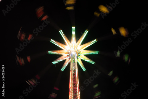 Colorful neon swinging carousel ride at night at the San Diego County Fair in California