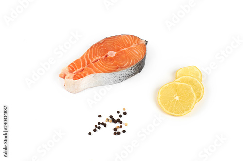 fresh steak of a red fish salmon with lemon and pepper, isolated on white background.