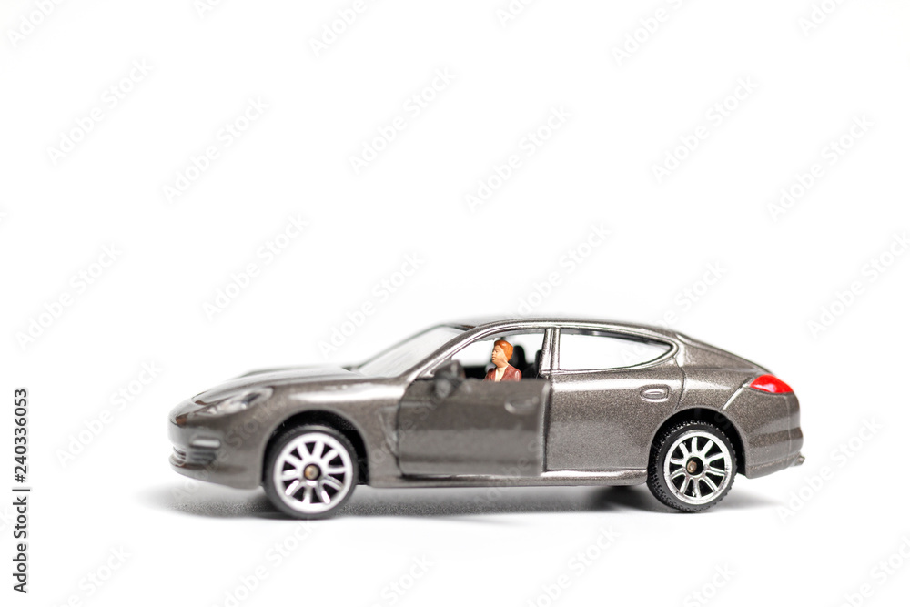 Miniature people sitting on car with copy space