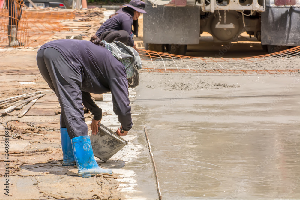 Construction worker pouring cement for doing the road. Construction worker pouring cement for doing the road.