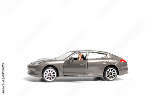 Miniature people sitting on car with copy space