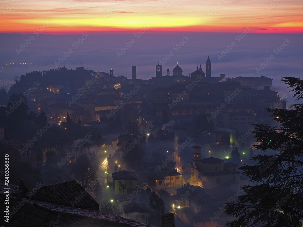 Obraz Bergamo, one of the most beautiful city in Italy. Lombardy. Amazing landscape of the fog rises from the plains and covers the old town at sunrise