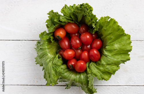 tomatoes herry into salad leaves photo