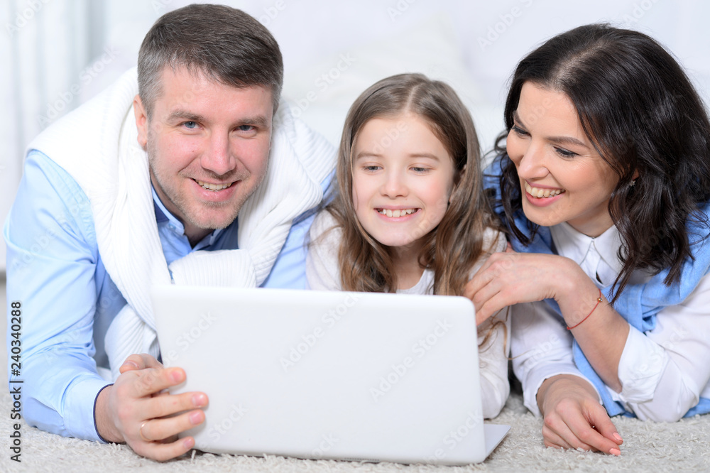 Close up portrait of parents and daughter using laptop in room Close up portrait of parents and daughter using laptop in room