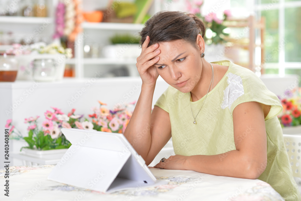Portrait of beautiful young sad woman using digital tablet Portrait of beautiful young sad woman using digital tablet