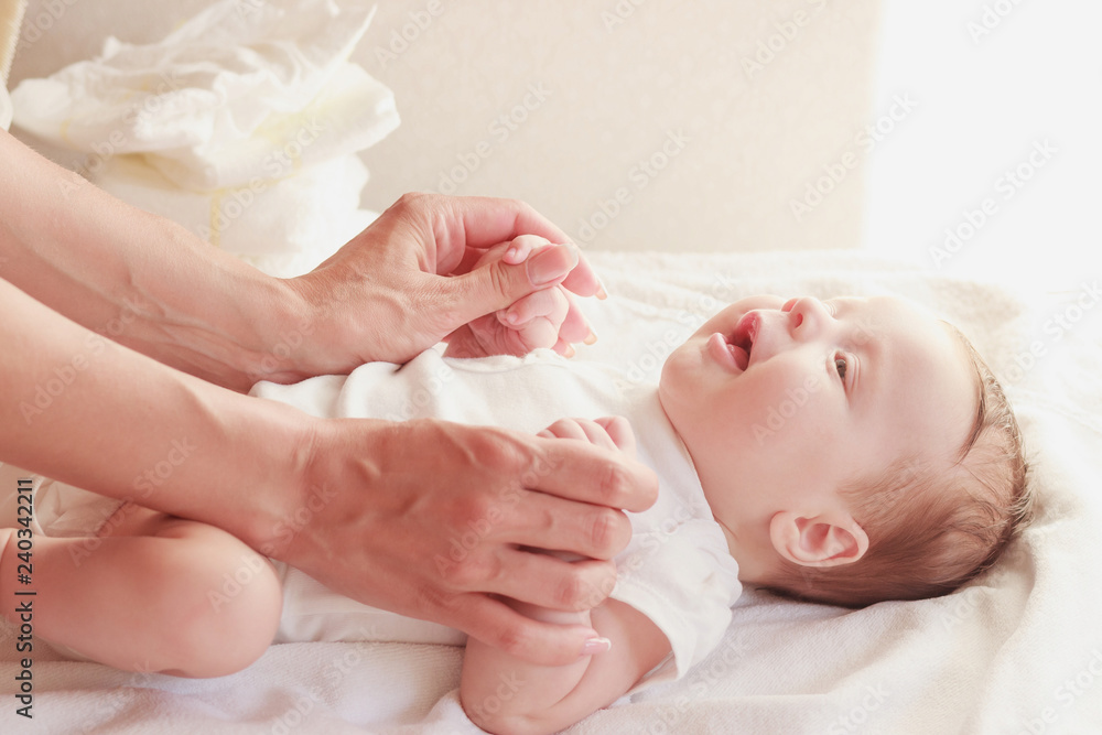 Baby and hands of mother, indoors, blurred background