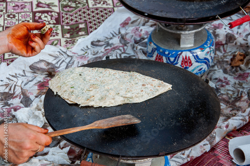 Baking traditional Turkish borek, gozleme, pide, pita or yufka bread. Borek, bread or pastry dough on the oven. Traditional Turkish food culture or cuisine. photo