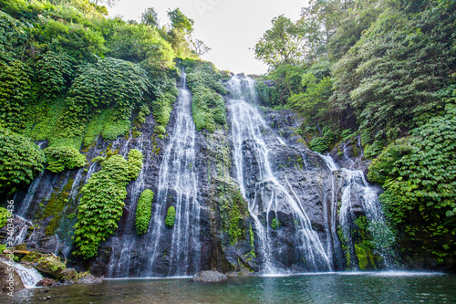 Banyumala twin waterfalls with cascades among green tropical trees and plants on the north of Bali island, Indonesia