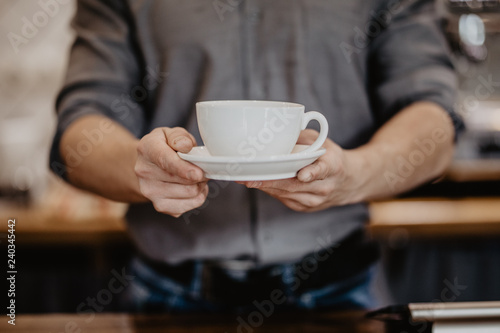 Barista hands prepares cappuccino in his coffee shop. close up