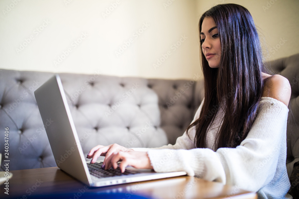 Young woman working with her laptop, coffee on desk in cafe shop Young woman working with her laptop, coffee on desk in cafe shop