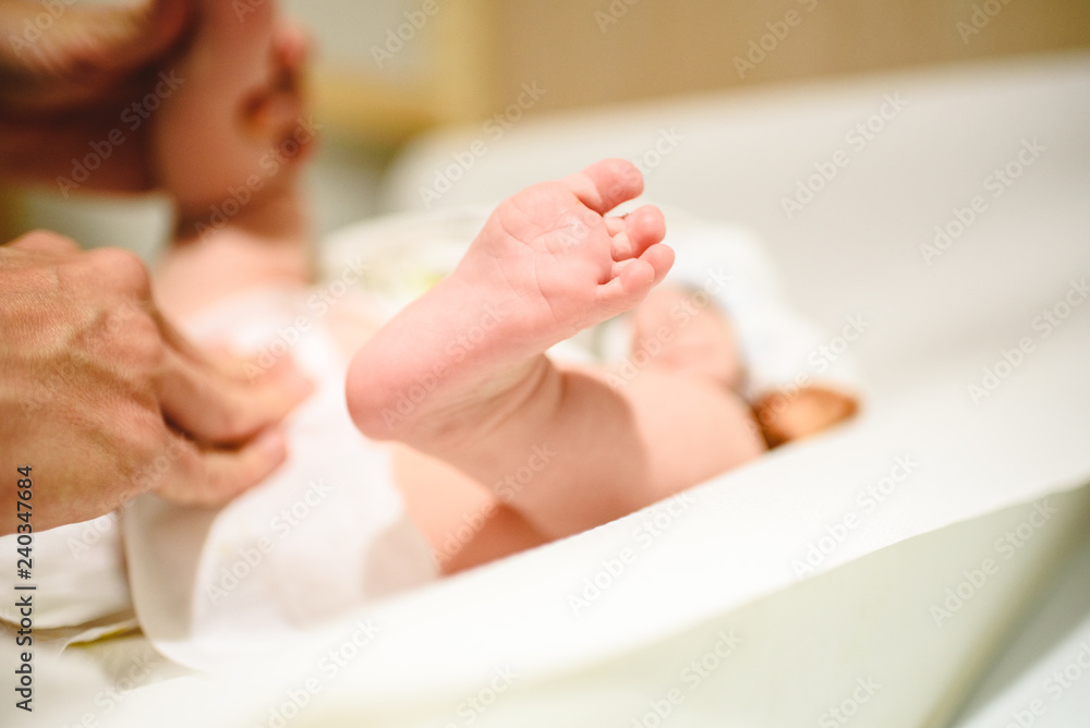 Mother changing diaper to baby, bare foot of her baby. Mother changing diaper to baby, bare foot of her baby.
