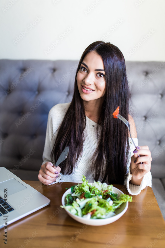 Smilingyoung woman eating fresh salad in restaurant Smilingyoung woman eating fresh salad in restaurant