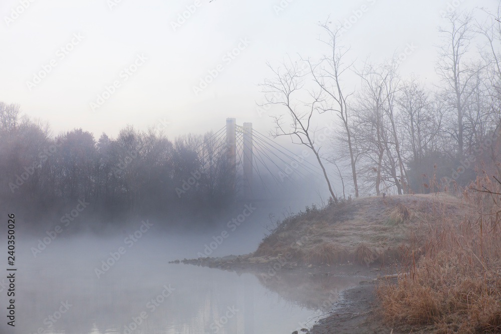 un pilastro di un ponte avvolto dalla nebbia invernale