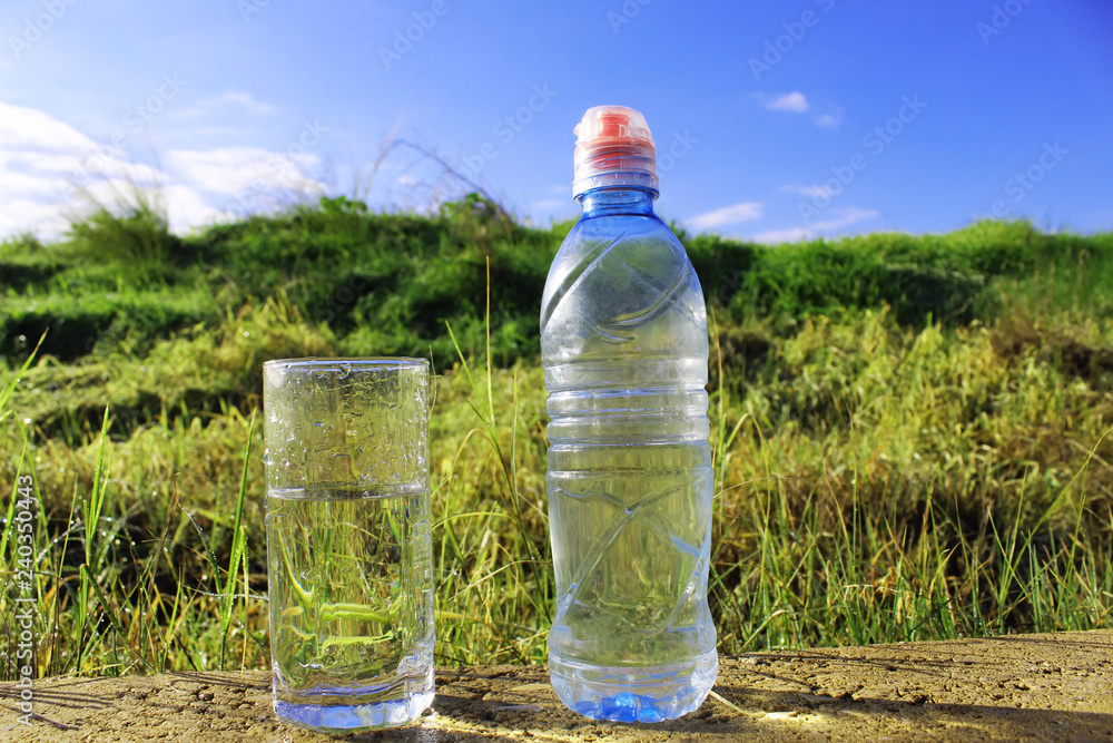 Water. Cold mineral water in a glass beaker and plastic water bottle