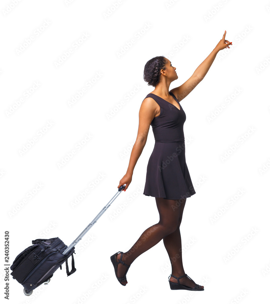 Back view of a black African-American iwalking with a suitcase and pointing hand forward. Back view of a black African-American iwalking with a suitcase and pointing hand forward.