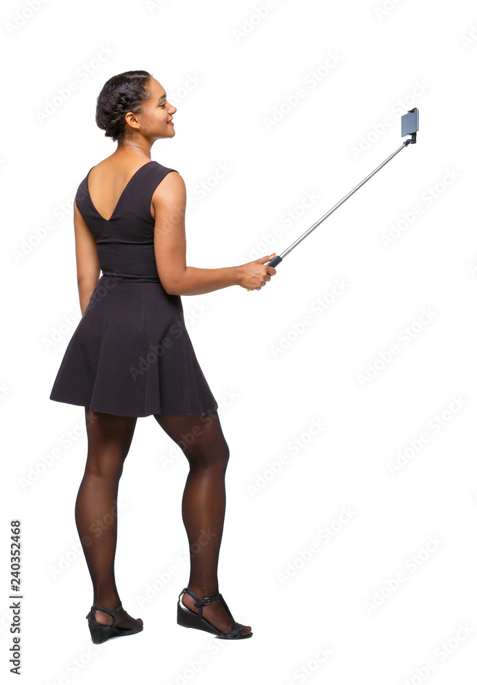 Back view of an African-American woman taking a selfie. Back view of an African-American woman taking a selfie.
