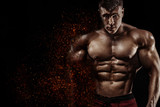 Brutal strong muscular bodybuilder athlete man pumping up muscles on black background. Workout bodybuilding concept. Copy space for sport nutrition ads.