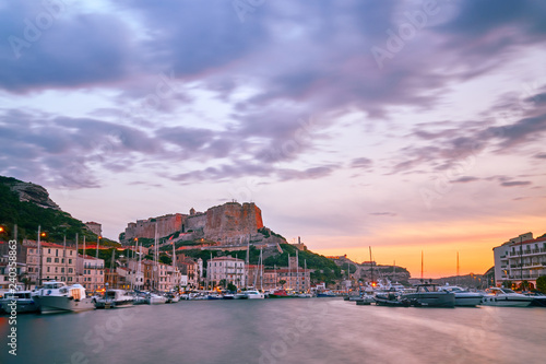Citadel of Bonifacio and the city port during beautiful colorful summer sunset in Corsica