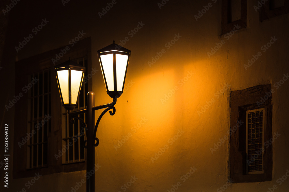 Straßenlampe am Abend vor Hauswand